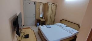 a small room with a bed and a television at Hotel shri annalakshmi lodge in Theni