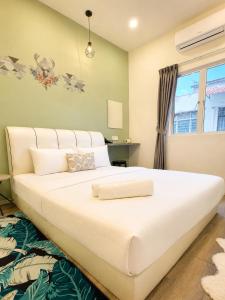 a large white bed in a room with a window at Casa Le Rock in Kuah