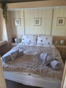 a bedroom with a large bed with blankets and pillows at Serenity in Monreith