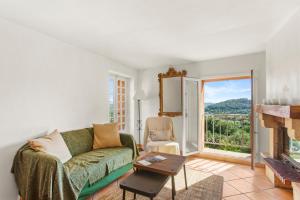 a living room with a green couch and a fireplace at La Villa Andéria in Callian