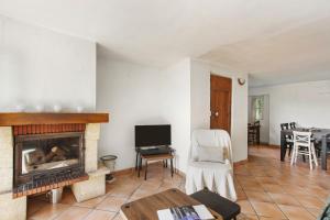 a living room with a fireplace and a table at La Villa Andéria in Callian