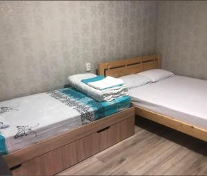 two twin beds in a room with wooden floors at Comfort in Reni