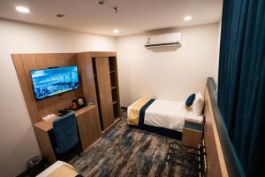 a hotel room with a bed and a flat screen tv at Alhijra View 2 - فندق الهجرة فيو 2 in Mecca