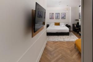 a bedroom with a bed and a tv on a wall at Theodor Rothschild Tel-Aviv in Tel Aviv