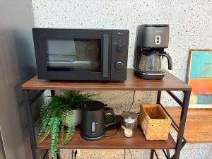 a microwave sitting on a shelf with a coffee maker at OTE HOUSE shime in Shime