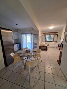 a dining room with a table and chairs and a living room at nikol villa elani in Siviri