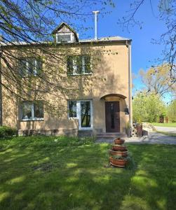 a large stone house with a stack of steps in the yard at Vilimiškės Apartamentai in Palanga