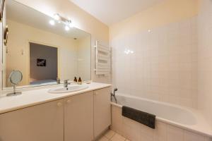 a bathroom with a sink and a tub and a mirror at Chambres d'hôtes Château Cajus in Saint-Germain-du-Puch +32 photos