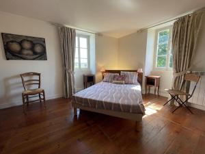 a bedroom with a bed and a table and chairs at Chez cazalets in Susmiou