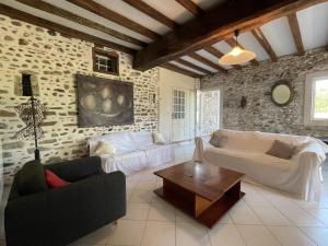 a living room with two couches and a table at Chez cazalets in Susmiou