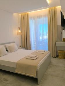 a bedroom with a large bed with towels on it at Calm Luxury Villas in Limenaria +28 photos