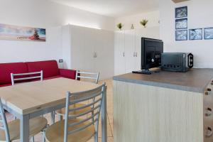 a kitchen and living room with a table and a television at Studio Apartment Lake and Relax in Gravedona