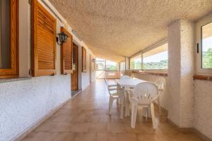 a dining room with a table and chairs and windows at Casa Vacanza Iris in Perdaxius
