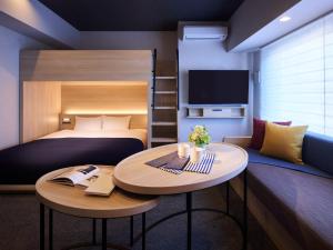 a hotel room with a bed and a table and a couch at Minn Namba South in Osaka +18 photos