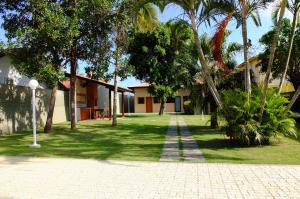 um quintal com palmeiras e um edifício em Suites Grande Tenorio em Ubatuba
