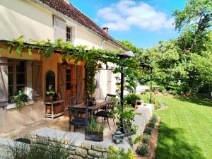 an outdoor patio with a table and a pergola at La lande sèche in Lainsecq