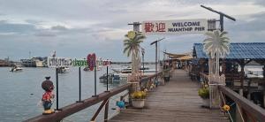 a wooden dock with a marina with a welcome sign at Relax Inn in Ban Phe
