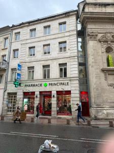 a building on a street with people walking in front of it at Heritage Suites- Palais des Papes & Pont d'Avignon- Clim in Avignon