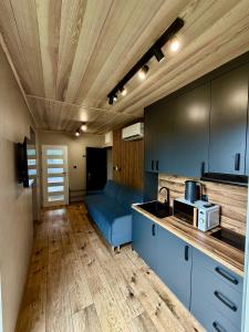 a kitchen with blue cabinets and a blue couch at Przystań Caryńska w Polańczyku in Polańczyk