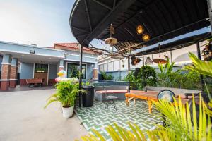 a patio with a table and chairs and plants at Richpoolvilla Pattaya in Jomtien Beach