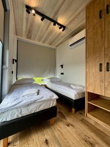 two beds in a room with wooden floors and ceilings at Przystań Caryńska w Polańczyku in Polańczyk +62 photos