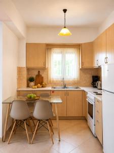 a kitchen with a table and chairs and a white refrigerator at Lina's House in Syvota