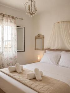 a bedroom with a white bed with two towels on it at Lina's House in Syvota