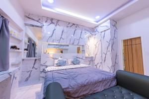 a bedroom with a bed and a marble wall at Richpoolvilla Pattaya in Jomtien Beach +75 photos