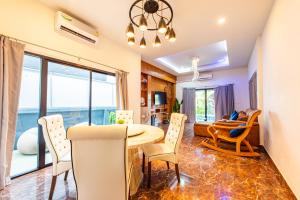 a dining room and living room with a table and chairs at Richpoolvilla Pattaya in Jomtien Beach