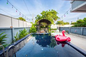a swimming pool with two inflatable flamingos on a house at Richpoolvilla Pattaya in Jomtien Beach