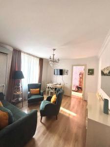 a living room with a couch and chairs and a table at Cozy Family Apartment in Tbilisi City