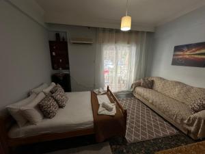 a living room with a bed and a couch at LADY E. in Kavála