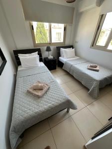 a bedroom with two beds with towels on them at LC Palm Villa in Protaras +25 photos