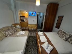 a living room with two beds and a tv at LADY E. in Kavála