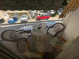 a balcony with a table and chairs and a car in a parking lot at LADY E. in Kavála
