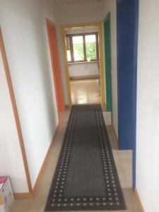 a hallway with a black floor mat in a room at LeaID in Idstedt