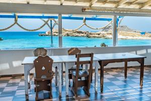 a table and chairs with a view of the ocean at Zorbas Studios in Lefkos Karpathou