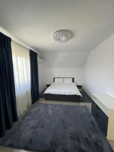 a white room with a bed and a window at Chill Garden House in Satu Mare