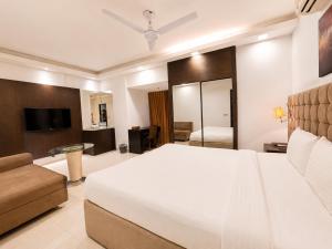 a bedroom with a large white bed and a television at Blossom Hotel Dhaka in Dhaka +29 photos
