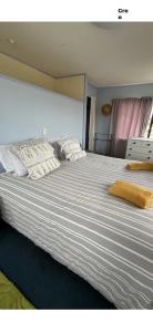 a large bed with two pillows on top of it at Beach Break Inn in Whitianga