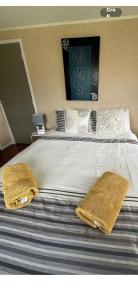 a bed with two yellow towels on top of it at Beach Break Inn in Whitianga