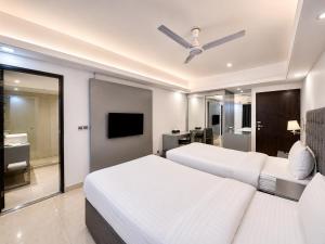 a hotel room with two beds and a television at Blossom Hotel Dhaka in Dhaka