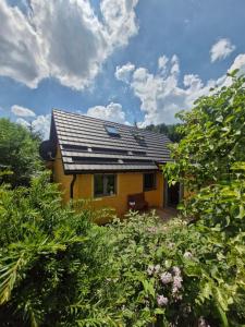 a house with a solar roof on top of it at Osada Bura Polana - drewniane domki z sauną in Ujsoły