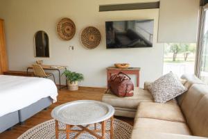 a living room with a couch and a bed at Stroomrivier Lodge in Boshoek +20 photos