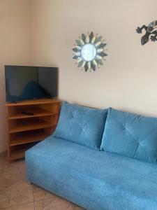 a blue couch in a living room with a tv at Forum - pensjonat przy plaży in Dźwirzyno