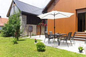 a table and chairs with an umbrella in a yard at Apartman ''Kod bake'' Delnice biker-friendly in Delnice