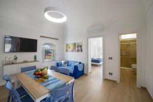 a living room with a table and a blue couch at Villa CristAl in Praiano
