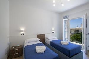a bedroom with two beds and a large window at Villa CristAl in Praiano