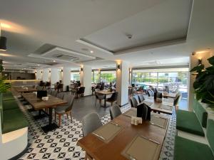 a restaurant with wooden tables and chairs and windows at Göcek Lykia Resort Premium Concept Hotel in Göcek