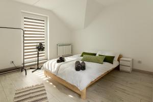 a bedroom with a bed with shoes on it at Apartament Nowinka in Tatary